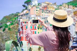 mujer joven tomando selfie antecedentes hermoso antiguo pueblo italiano, cinque terre, liguria foto