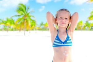 Beautiful little girl at beach having fun. Funny girl enjoy summer vacation. photo