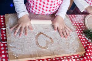 Heart drawn in flour on the board and kid's hands photo