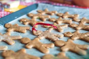 Raw gingerbread men on a baking photo