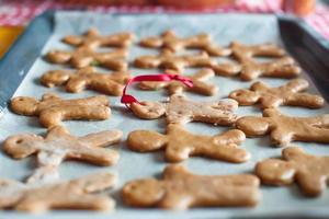 Raw gingerbread men on a baking photo
