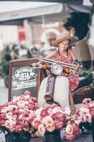 Adorable little girl in hat on the moped outdoors photo
