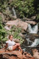 Little girl enjoying view of waterfall in Krasnay Poliana photo