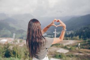 Beautiful happy young woman in mountains in the background of fog photo