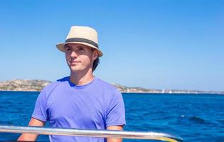 The young man at the helm of small boat photo