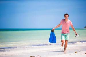 Young man with mask and fins. Holiday vacation on a tropical beach. photo