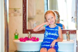 Dental hygiene. Adorable little smile girl brushing her teeth photo