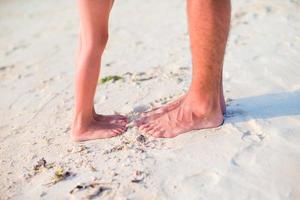 Closeup kids and adult feet on white sandy beach photo