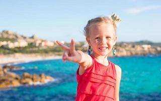 Adorable little girl having fun at tropical beach photo