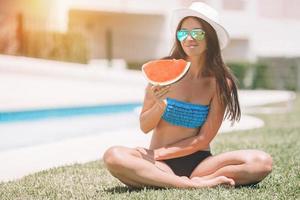 Young woman with watermelon relaxing outdoor at summer vacation photo