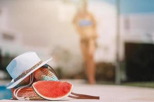 Colorful beach bag, glass of juice, straw hat and airplane model photo