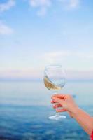 Glass of white wine on tropical beach photo