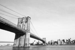 puente de brooklyn sobre el río este visto desde la ciudad de nueva york. en blanco y negro. foto