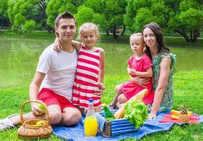 Happy young family picnicking outdoors photo