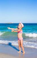 niña feliz durante las vacaciones en la playa tropical foto