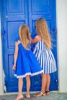 Lindas niñas en la calle del típico pueblo tradicional griego en Grecia foto