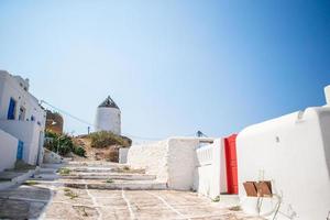 The narrow streets with blue balconies and stairs. Beautiful architecture building exterior with cycladic style. photo