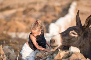 Little girl with donkey on the island of Mykonos photo