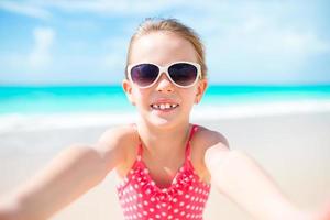 Cute little girl at beach during summer vacation photo