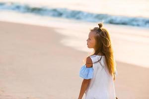 Adorable little girl at beach during summer vacation photo