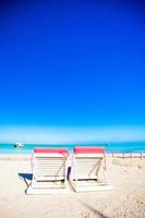 Beach sunbeds on white sand beach photo