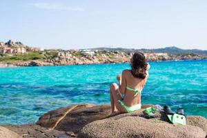 Young woman with snorkeling equipment on big stones photo