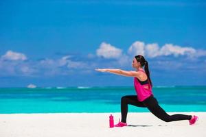 Healthy athlete woman working out doing exercise on tropical white beach photo