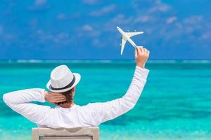 Young man with miniature of an airplane at tropical beach photo