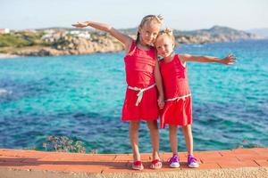 Adorable little girls at tropical beach during summer vacation photo