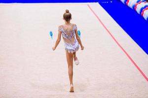 hermosa niña gimnasta activa con su actuación en la alfombra foto