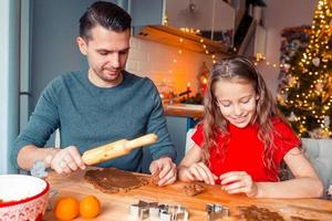 familia horneando galletas de jengibre en vacaciones de navidad foto