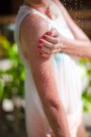 Young girl in tropical shower during beach vacaion photo