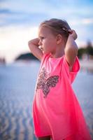 Adorable little girl having fun on white beach photo