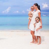 Mother and adorable girls during beach vacation photo