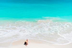 Adorable active girl at beach during summer vacation photo