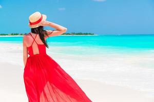 Beautiful woman on tropical seashore. Young girl in beautiful red dress background the sea photo