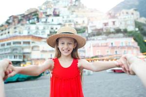 Adorable little girl on warm and sunny summer day in Positano town in Italy photo