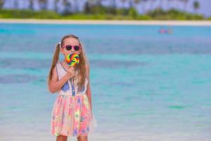 Adorable niña divertirse con paleta en la playa foto