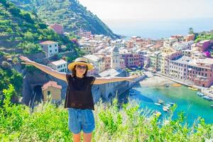 Young woman with beautiful view at old village in Cinque Terre, Liguria, Italy. European italian vacation. photo