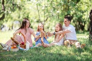 familia feliz en un picnic en el parque en un día soleado foto