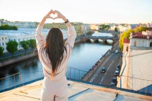 Woman on rooftop enjoying with view of beautiful sunset in Sankt Petersburg in Russia photo