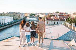Family on rooftop enjoying with view of beautiful sunset in Sankt Petersburg in Russia photo