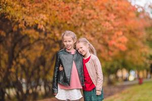 Little adorable girls outdoors at warm sunny autumn day photo