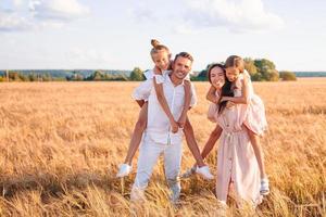 familia feliz jugando en un campo de trigo foto