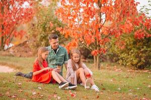 Family of dad and kids on beautiful autumn day in the park photo