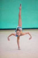 Little gymnast training on the carpet and ready for competitions photo