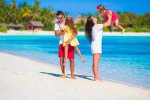 Happy family playing together on white beach photo