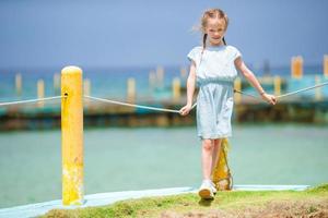 Adorable little girl at tropical resort during summer vacation photo