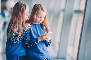 Little kids together in airport waiting for boarding photo