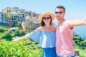 Happy family with view of the old coastal town background of Corniglia, Cinque Terre national park, Liguria, Italy ,Europe photo